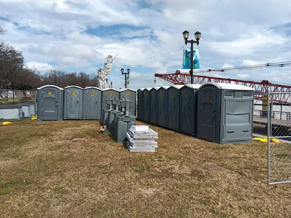 Row of Pelican Events porta potties and hand wash sinks at a riverfront event